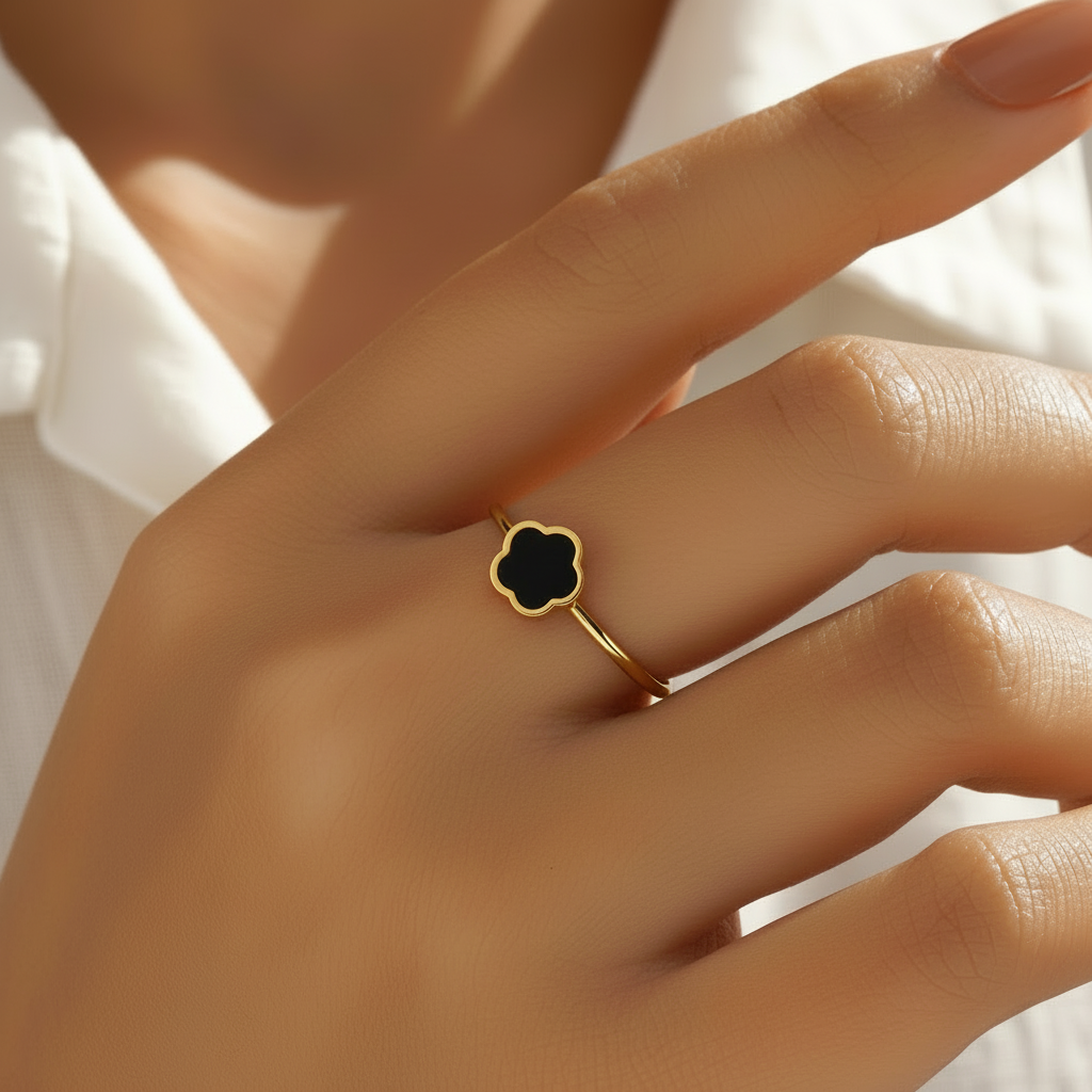 Main portant une bague dorée ajustable en acier inoxydable ornée d’une fleur en pierre naturelle agate noire.