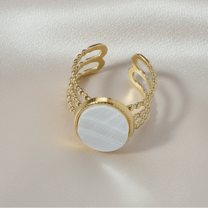 Gros plan sur une bague dorée en acier inoxydable avec nacre.