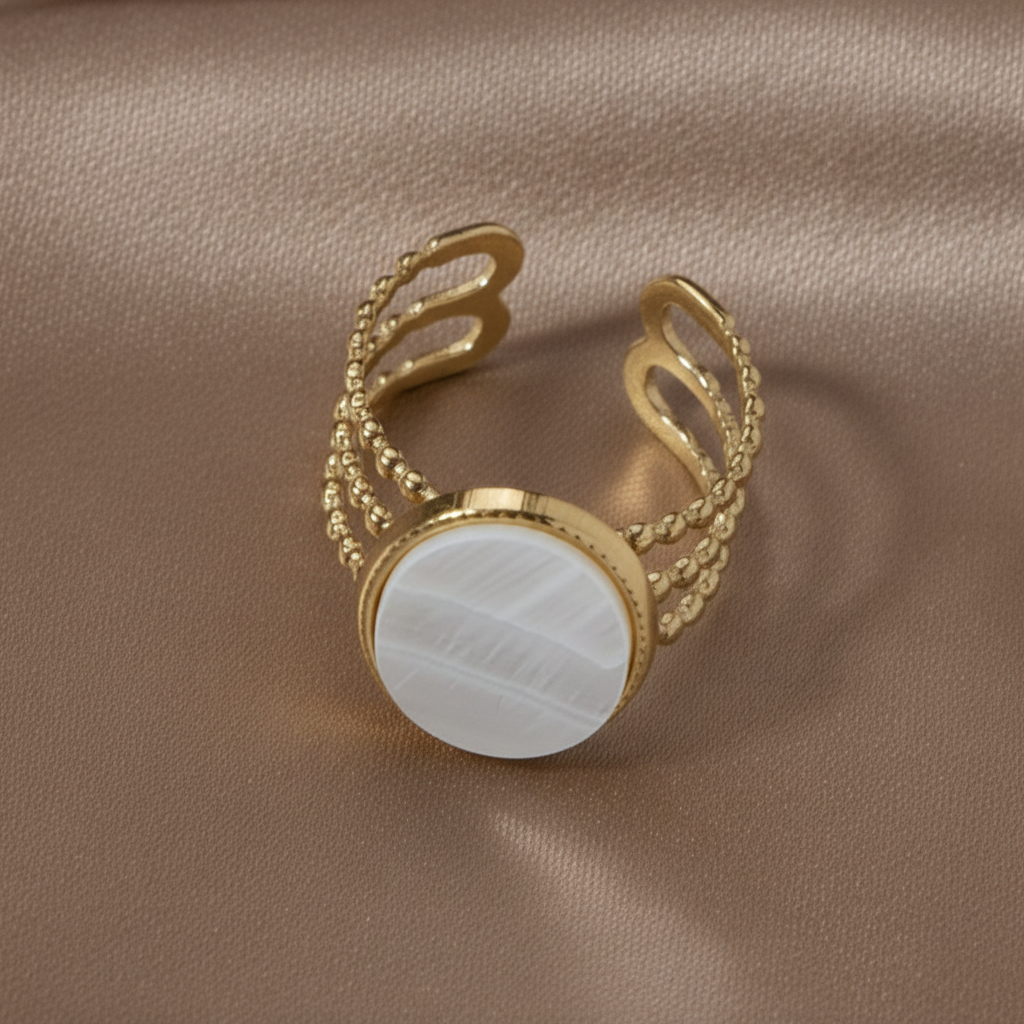 Gros plan sur une bague dorée en acier inoxydable avec nacre.