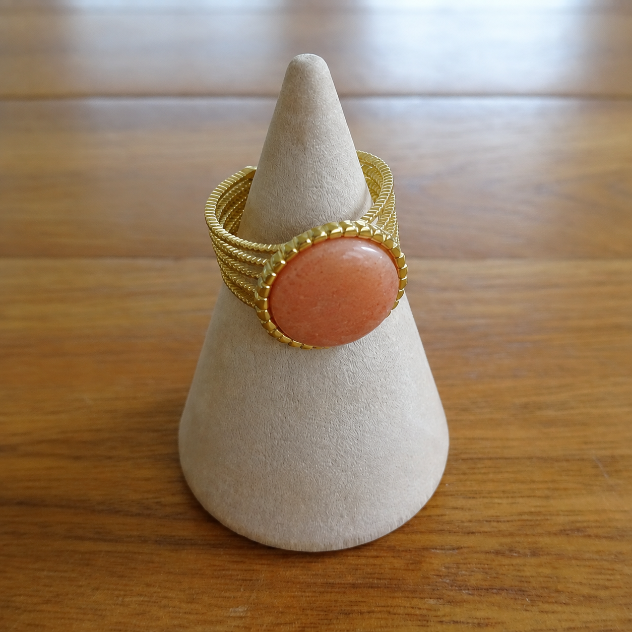 Gros plan sur une bague en pierre naturelle pierre de soleil et acier inoxydable 316L doré.