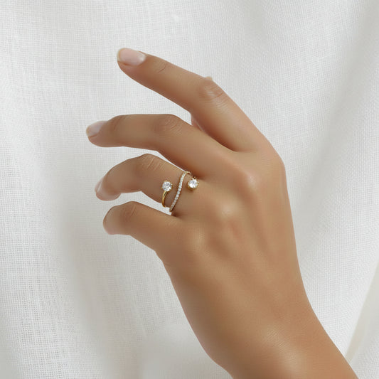 Main de femme portant une bague anneau dorée en acier inoxydable 316L avec zircons blancs.