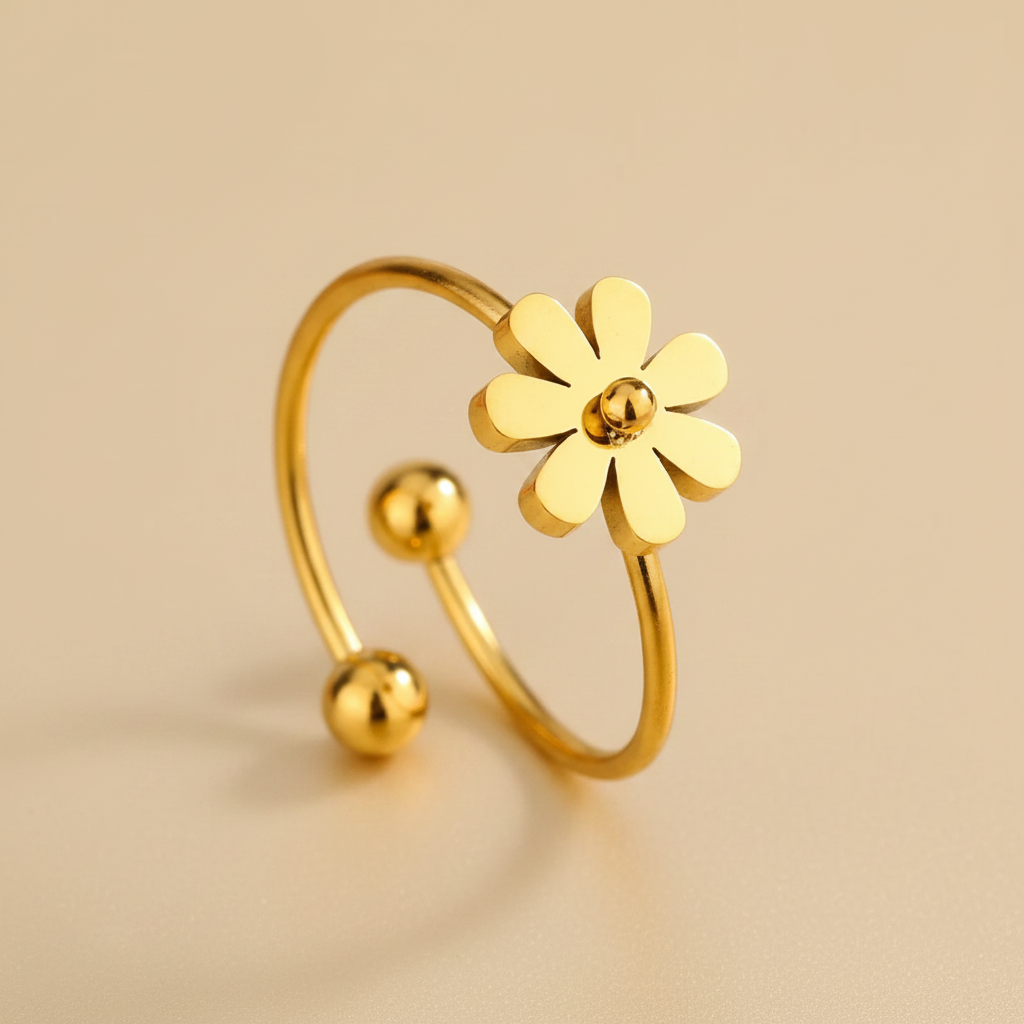 Gros plan sur une bague dorée en acier inoxydable 316L ornée d’une petite fleur en acier.