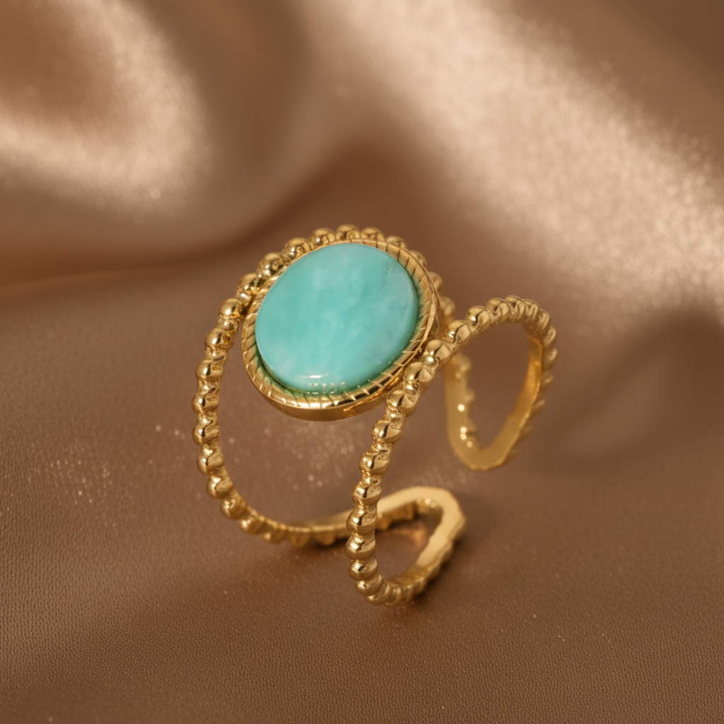 Gros plan sur une bague dorée en acier inoxydable ornée d’une pierre naturelle amazonite.