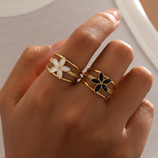 Bagues bandeau ajustables en acier inoxydable doré avec fleur blanche ou noire, portées sur la main d’une femme, bijou bohème