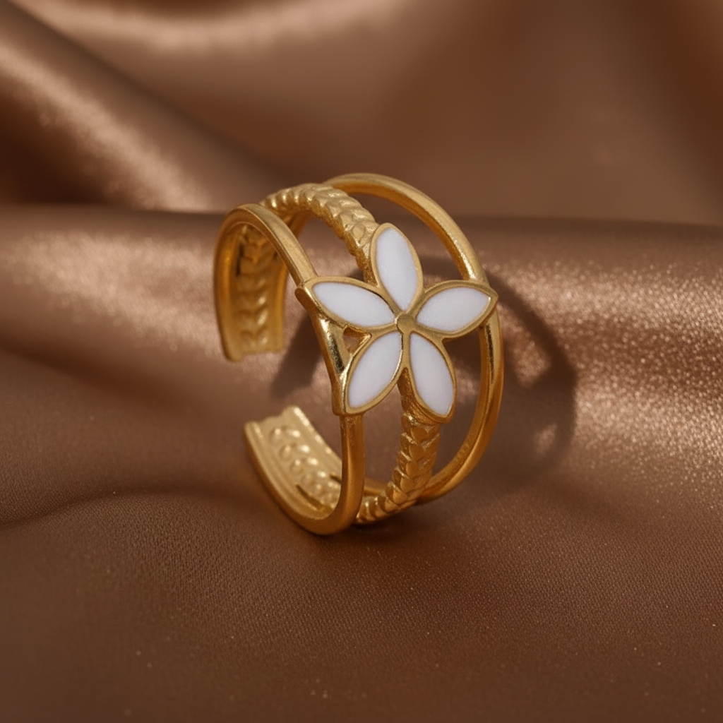 Bague bandeau ajustable en acier inoxydable doré, ornée d'une fleur blanche.