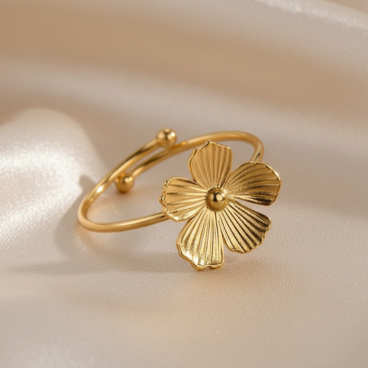 Gros plan sur une bague petite fleur stylisée ajustable en acier inoxydable doré.