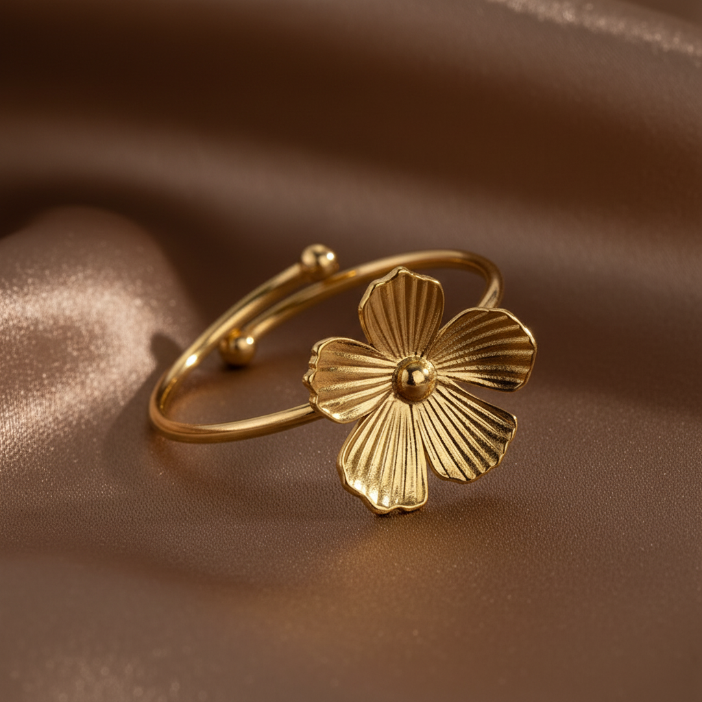 Gros plan sur une bague petite fleur stylisée ajustable en acier inoxydable doré.