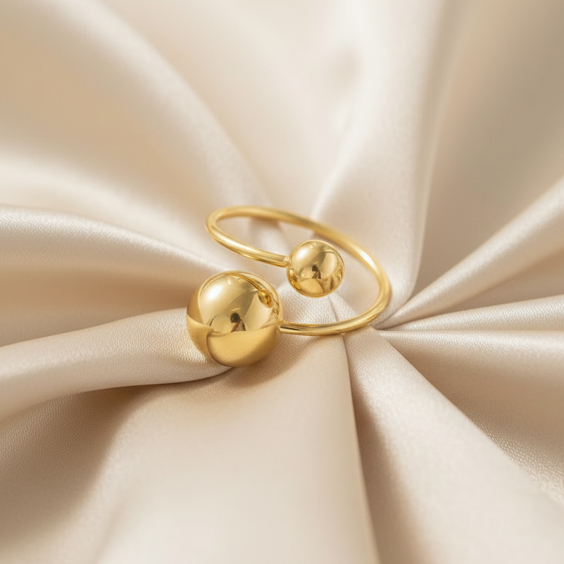 Bague en acier inoxydable doré ornée d'une grande et petite perle en acier.