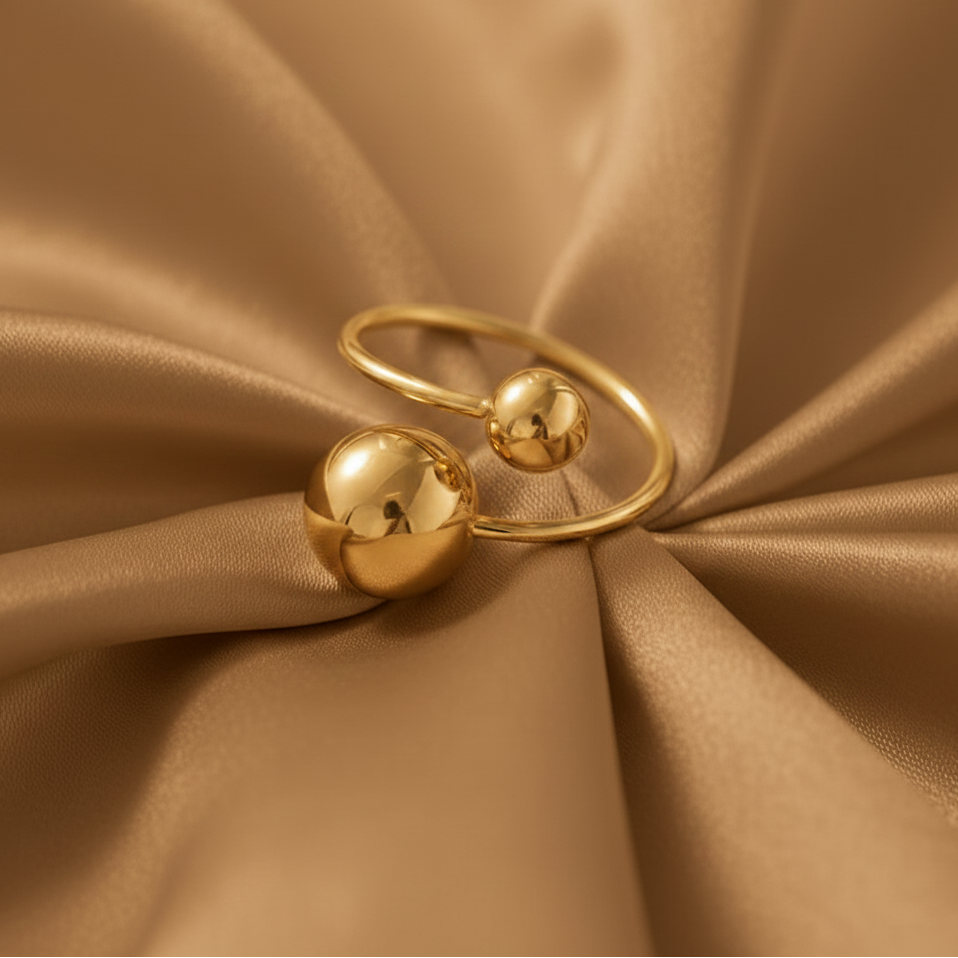 Bague en acier inoxydable doré ornée d'une grande et petite perle en acier.