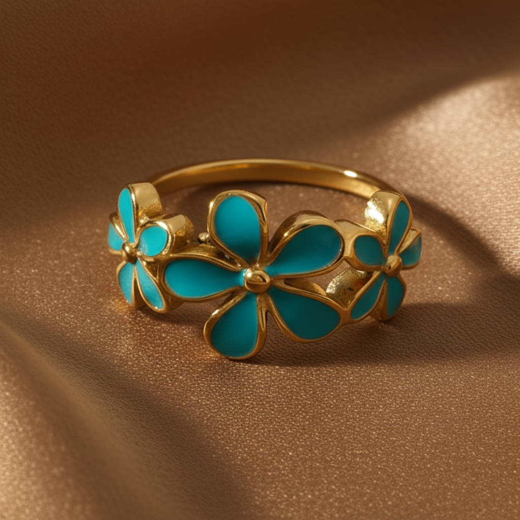 Bague dorée ajustable en acier inoxydable 316L avec trois fleurs en émail bleu.