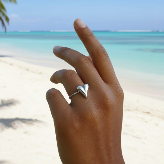 Main de femme portant une bague coeur en acier inoxydable 316L argenté.