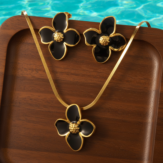 Parure à grande fleur émaillée noir en acier inoxydable doré composée d'un collier à maille serpent et boucles d'oreilles.