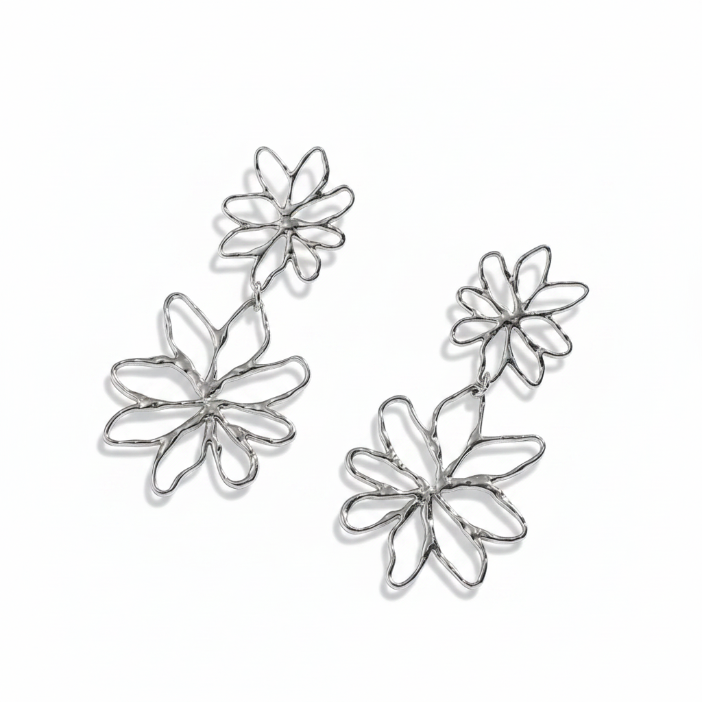 Boucles d’oreilles pendantes en acier inoxydable argenté ornées de deux fleurs stylisées ajourées, longueur 5 cm.