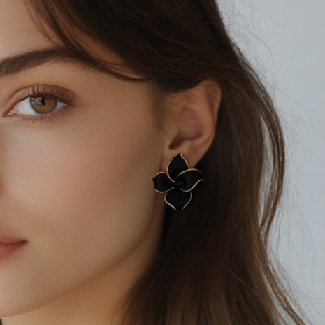 Femme portant des boucles d'oreilles fleur stylisée noire en acier inoxydable doré, puce 3 cm, bijou élégant