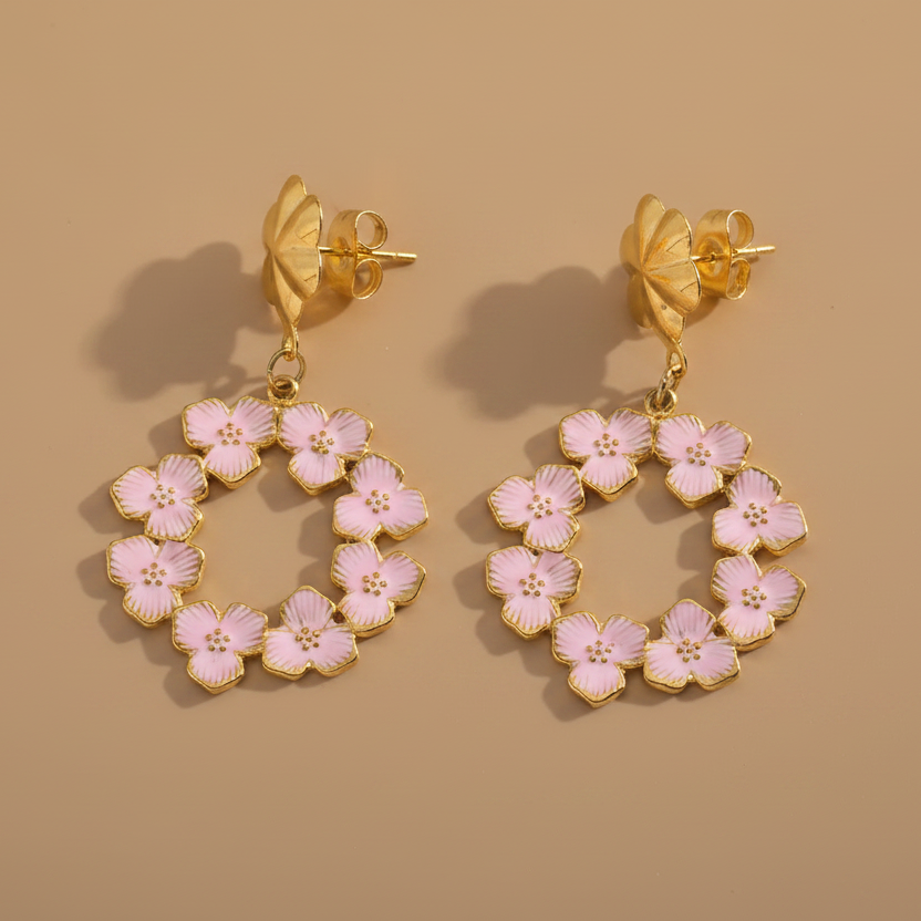 Boucles d'oreilles pendantes en acier inoxydable doré à couronne de fleurs en émail rose.