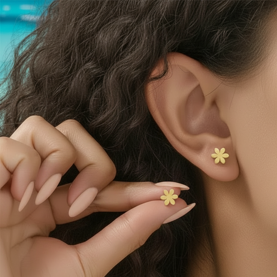Femme portant des boucles d'oreilles tendance fleur stylisée en acier inoxydable doré, puce 0,8 cm, style minimaliste