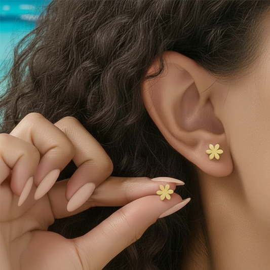 Femme portant des boucles d'oreilles tendance fleur stylisée en acier inoxydable doré, puce 0,8 cm, style minimaliste