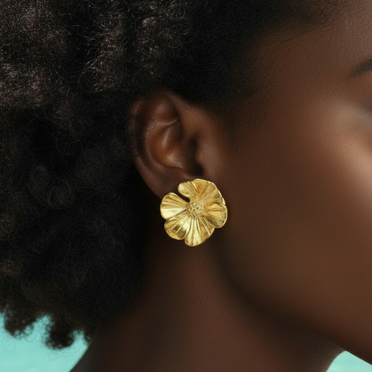 Femme portant des boucles d'oreilles fleur marguerite stylisée en acier inoxydable doré, puce 2,5 cm.