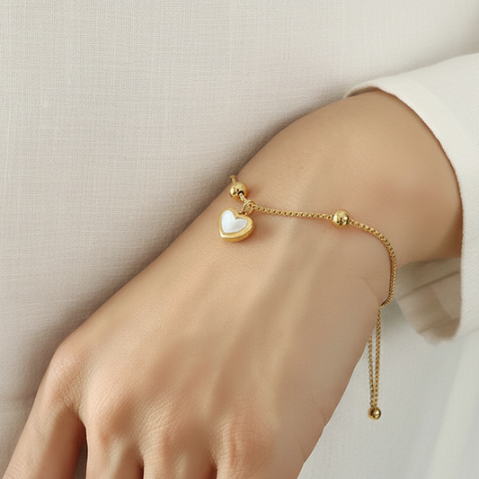 Femme portant un bracelet en acier inoxydable doré coulissant avec charm cœur en nacre