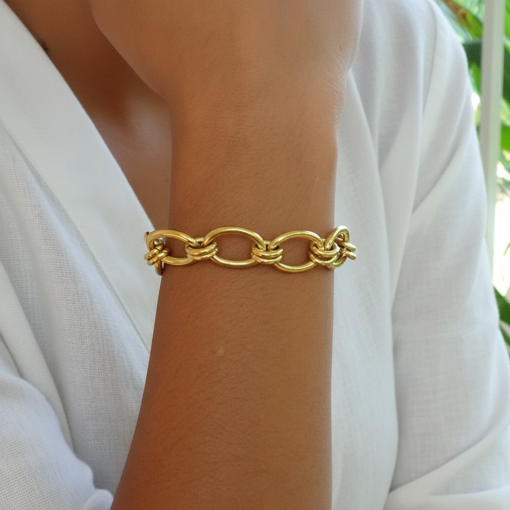 Bracelet doré en acier inoxydable 316L plaqué or 18K à grosse chaîne trombone porté au poignet.