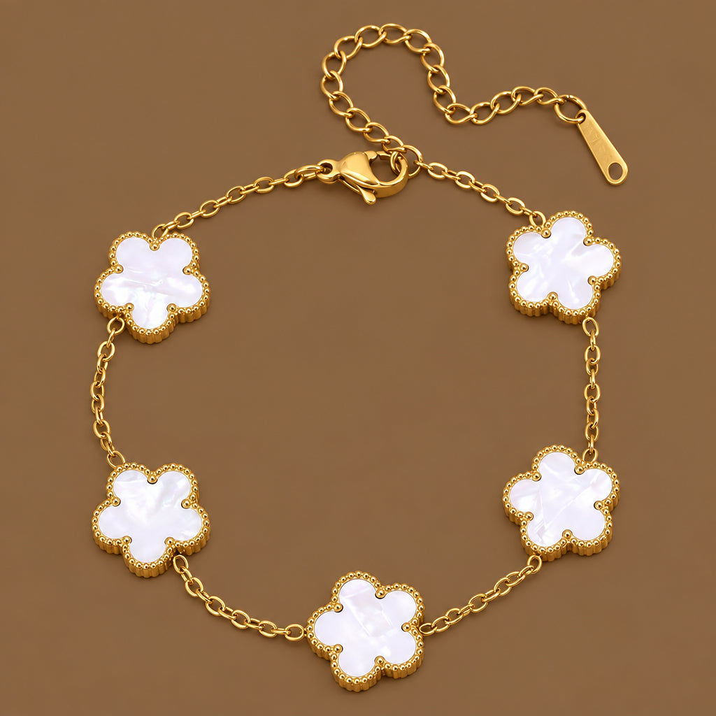 Bracelet en acier inoxydable 316L doré à chaîne fine orné de 5 fleurs en nacre naturelle.