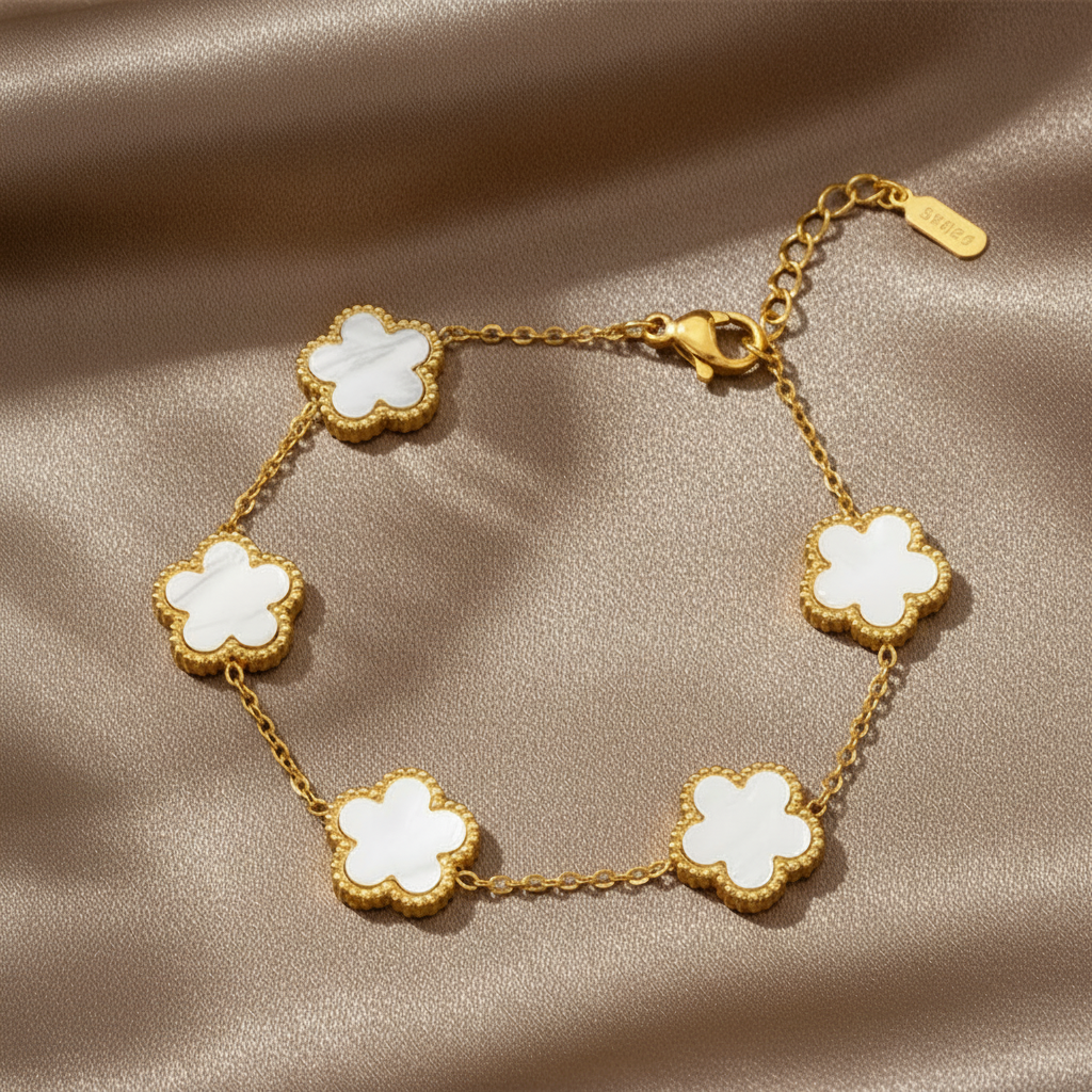 Bracelet en acier inoxydable 316L doré à chaîne fine orné de 5 petites fleurs blanches en nacre.
