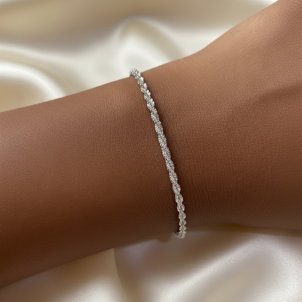 Bracelet argenté brillant en acier inoxydable 316L à maille corde fine porté au poignet.