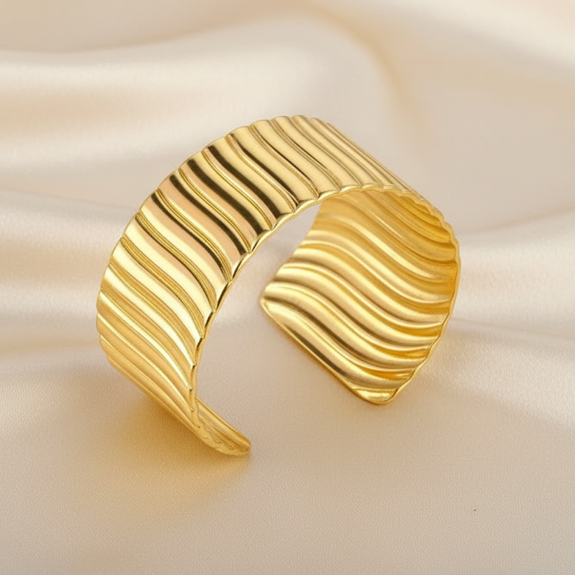 Bracelet manchette doré en acier inoxydable 316L martelé et stylisé.