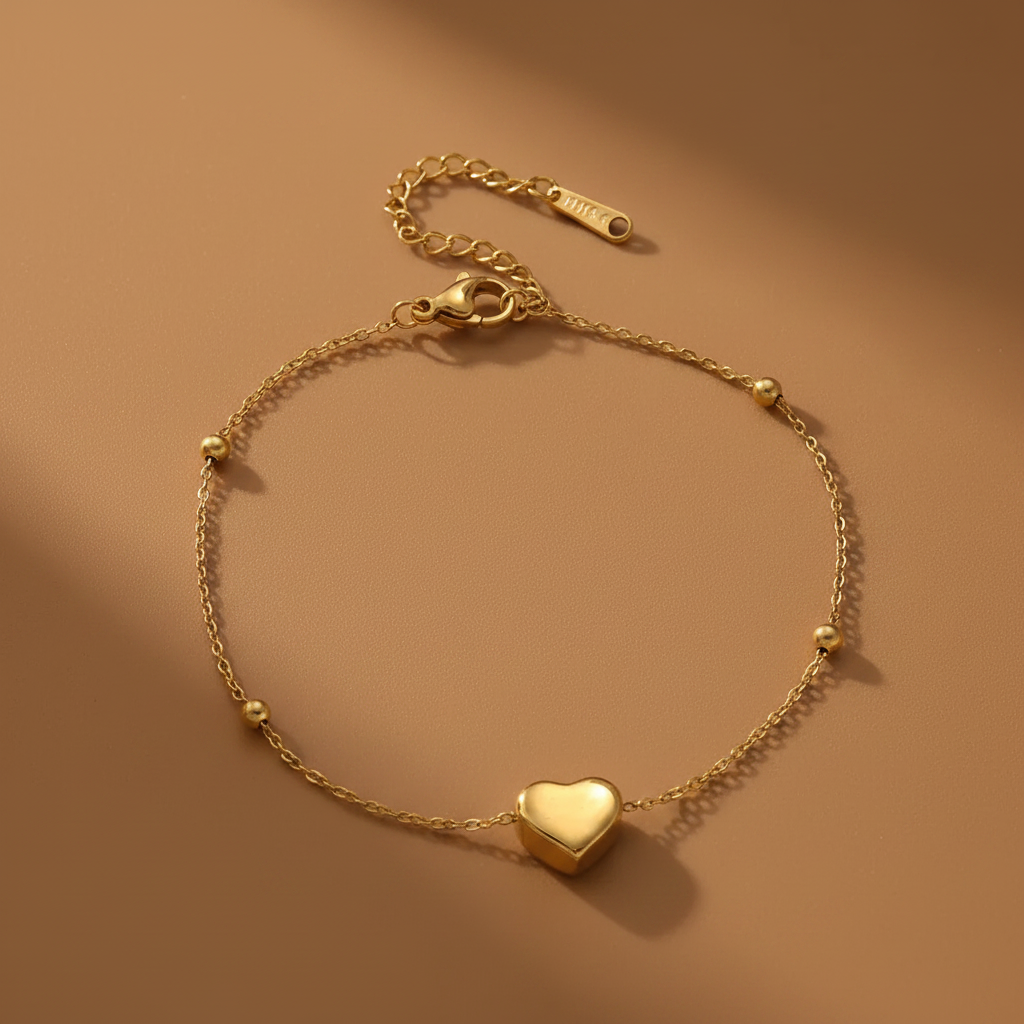 Bracelet de cheville doré en acier inoxydable 316L à chaîne fine ornée de 4 petites perles et d'un coeur.