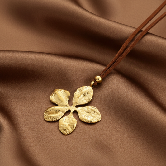 Collier à cordon en velours marron et pendentif grande fleur stylisée en acier inoxydable doré martelé.
