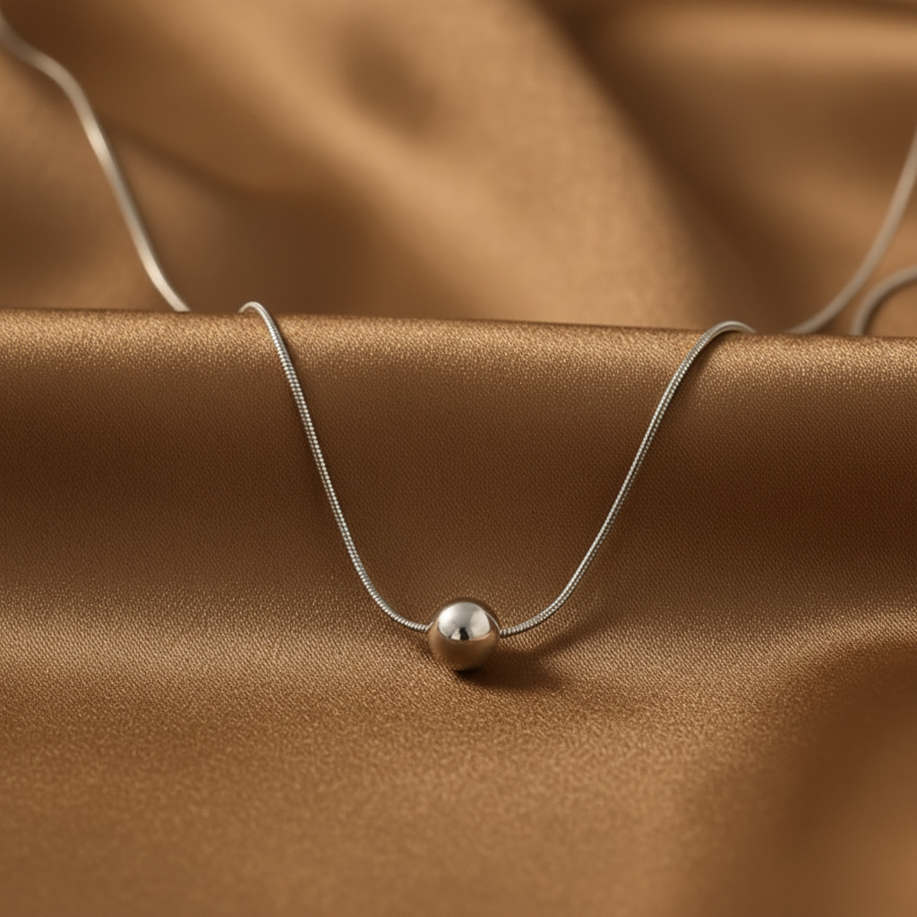 Collier en acier inoxydable à fine chaîne maille serpent avec pendentif grosse perle acier argenté.