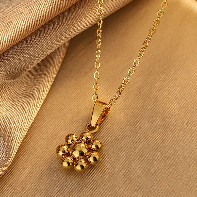 Collier doré en acier inoxydable avec fine chaîne maille forçat et pendentif fleur stylisée
