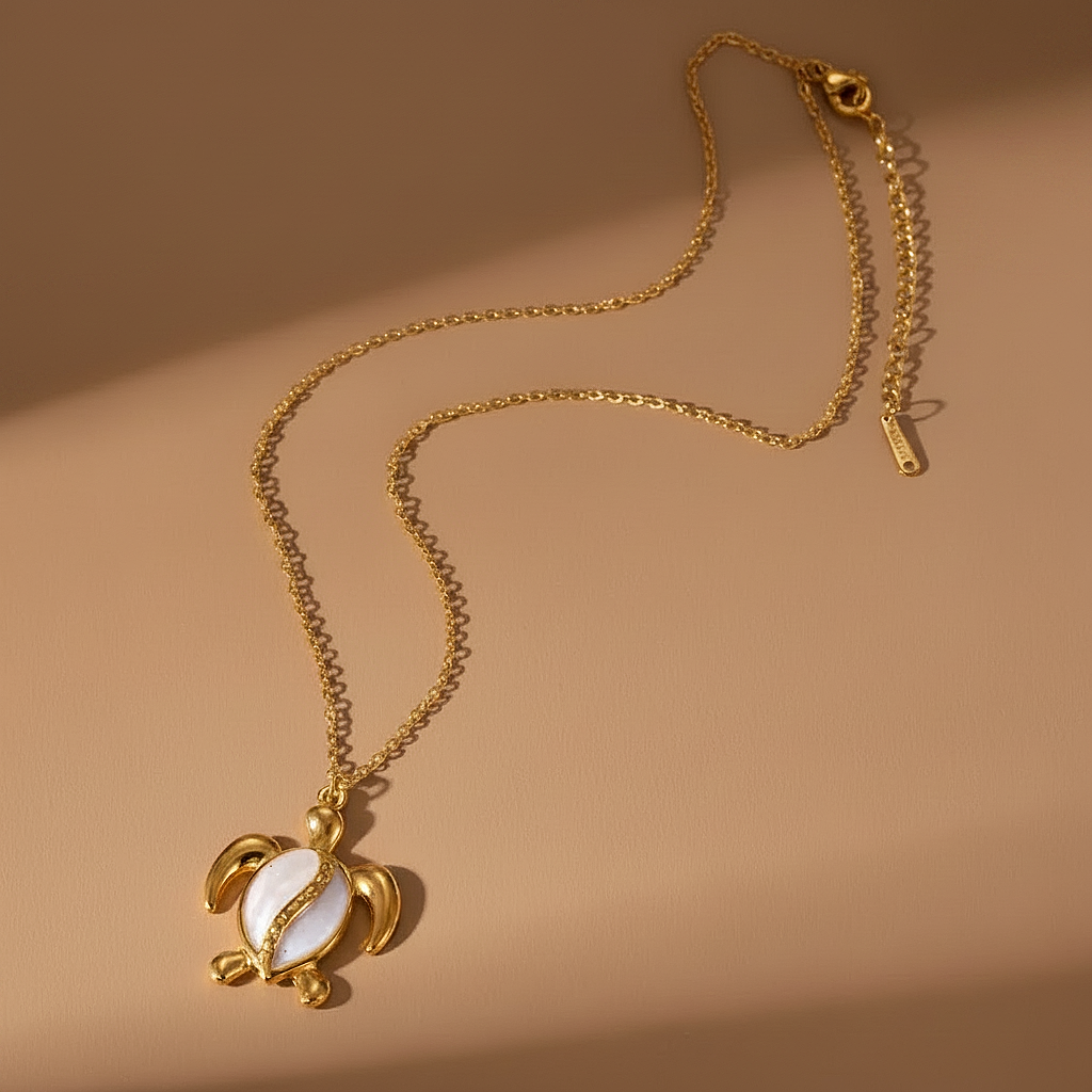 Collier doré orné d'un pendentif tortue en acier inoxydable émaillé blanc.