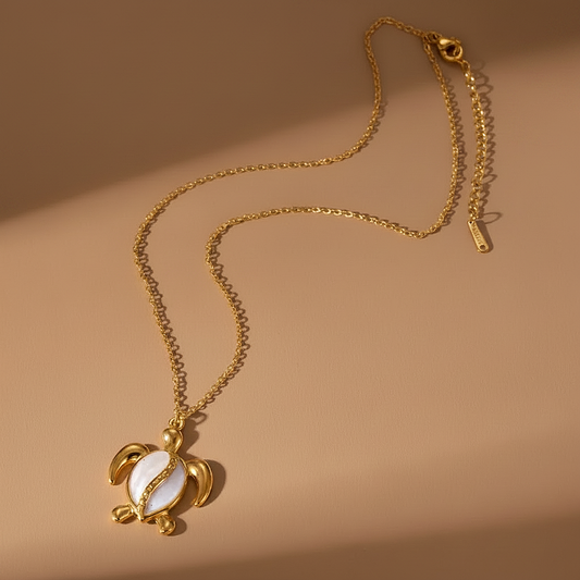 Collier doré orné d'un pendentif tortue en acier inoxydable émaillé blanc.