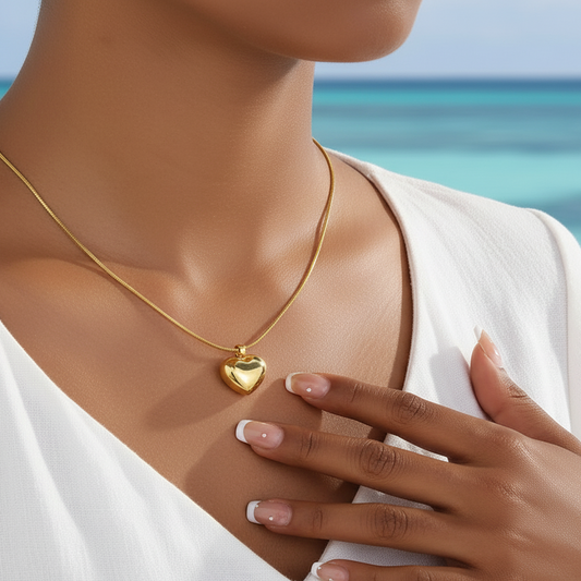 Femme portant un collier doré en acier inoxydable à maille serpent de 50 cm avec pendentif cœur exagéré, style bohème