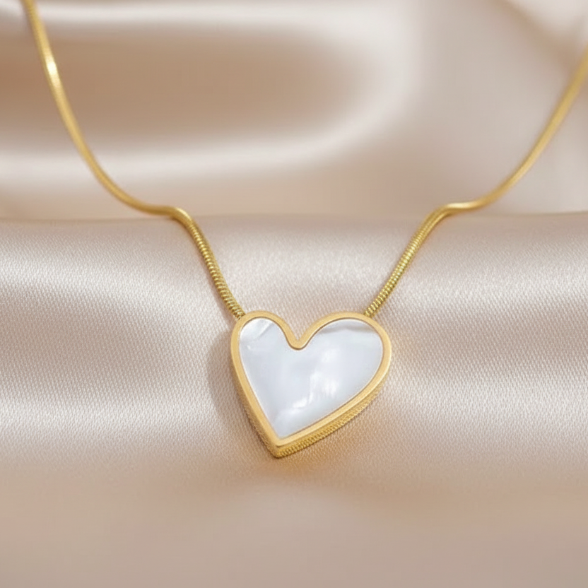 Zoom sur collier doré en acier inoxydable à fine chaîne maille serpent et cœur en nacre de 1,5 cm, bijou bohème
