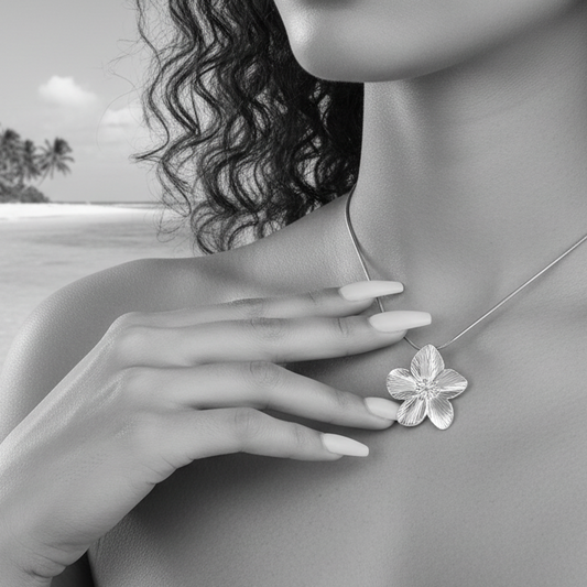 Collier argenté en acier inoxydable 316L à chaîne maille serpent orné d'un pendentif fleur tropicale porté par une femme.