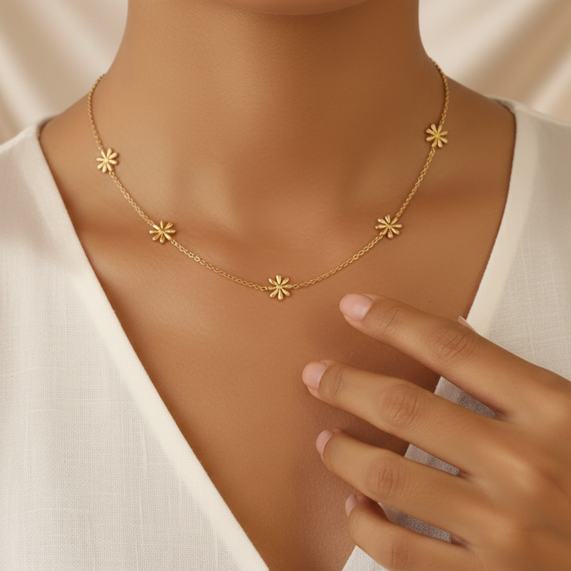 Femme portant un collier doré en acier inoxydable 316L avec 5 petites fleurs minimalistes.