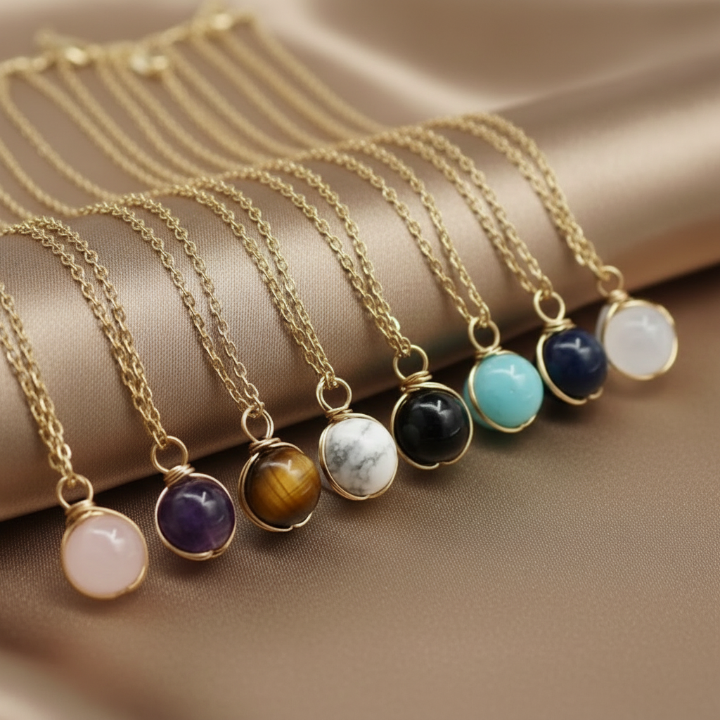Collier doré en acier inoxydable à chaîne fine maille forçat et pendentif boule en pierre naturelle.
