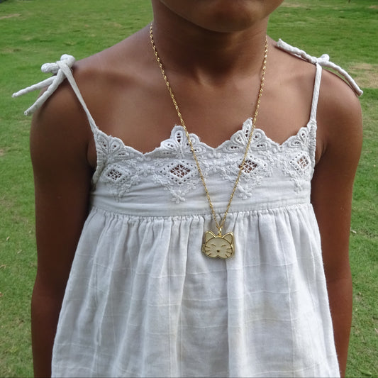 Collier doré en acier inoxydable à fine maille torsadée avec pendentif tête de chat ouvrant émaillé blanc porté.