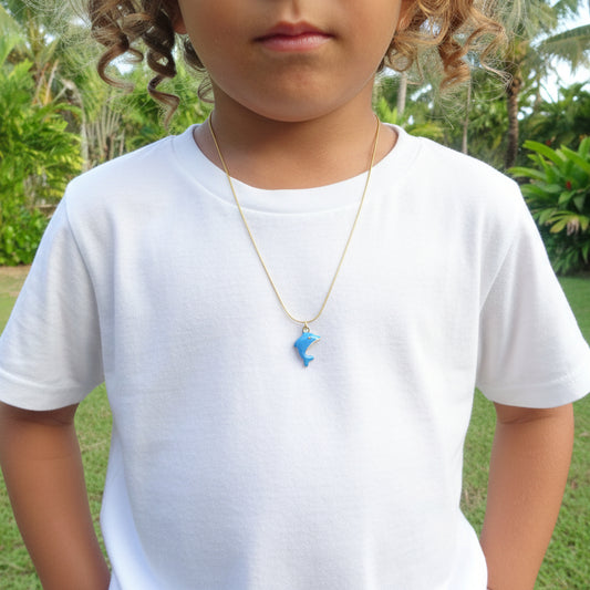 Collier enfant en acier 316L doré orné d'un pendentif dauphin émaillé bleu porté par un enfant.