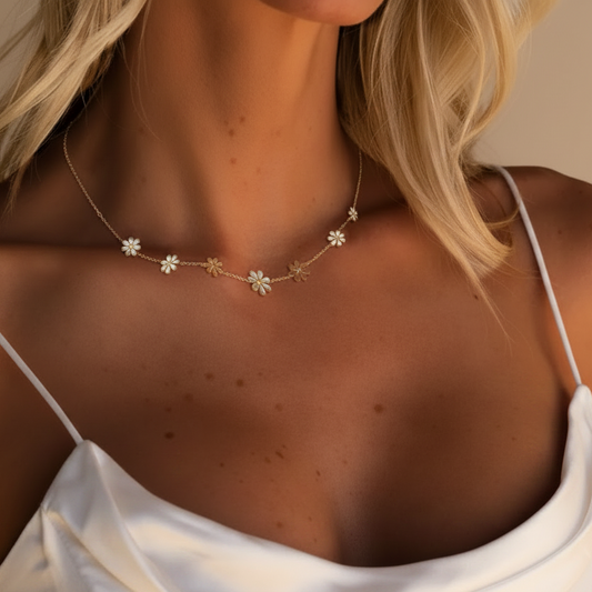 Collier doré en acier inoxydable 316L orné de 7 petites fleurs porté par une femme.