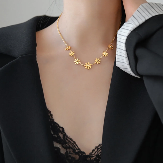 Femme portant un collier doré en acier inoxydable avec 7 petites fleurs, bijou bohème