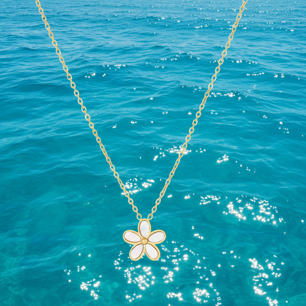 Gros plan sur un collier doré en acier inoxydable 316L orné d'un pendentif fleur en nacre.