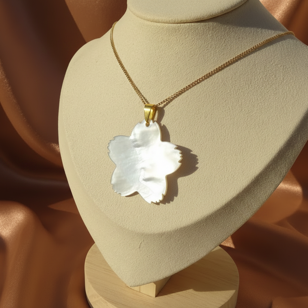 Envers du collier en acier inox 316L doré à chaîne maille gourmette et pendentif fleur des îles en nacre grise.
