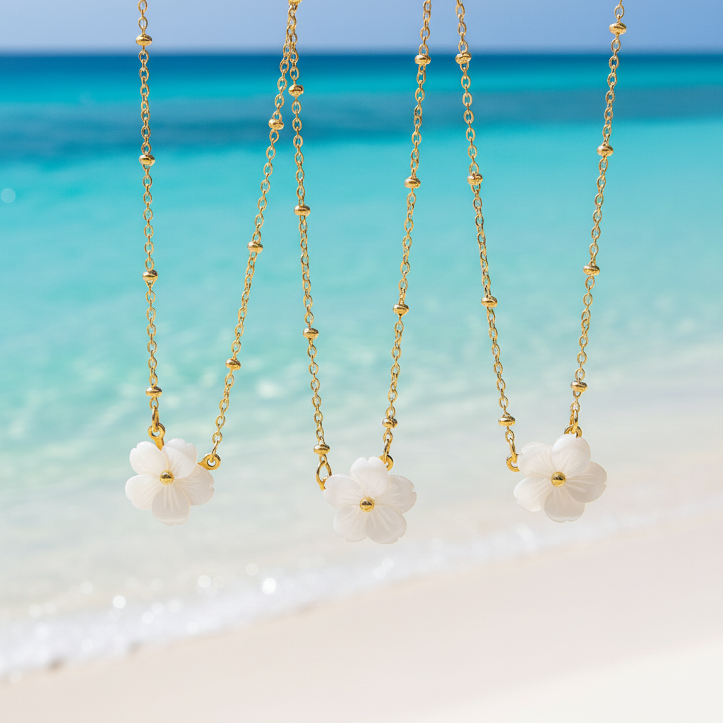 Collier en acier inoxydable doré à fine maille forçat perlée et pendentif fleur en nacre.