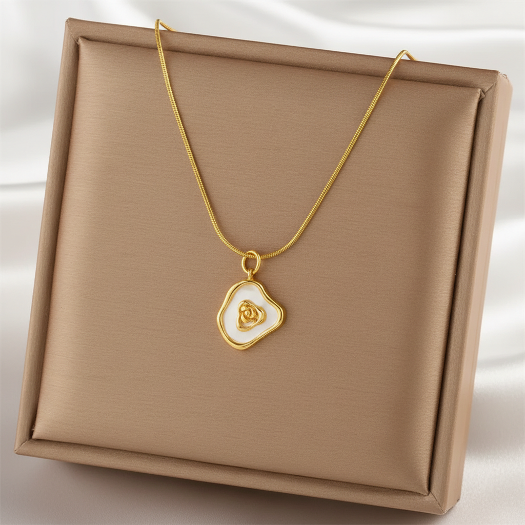Collier doré en acier inoxydable 316L à fine chaîne maille serpent orné d'un pendentif en nacre et coeur doré.