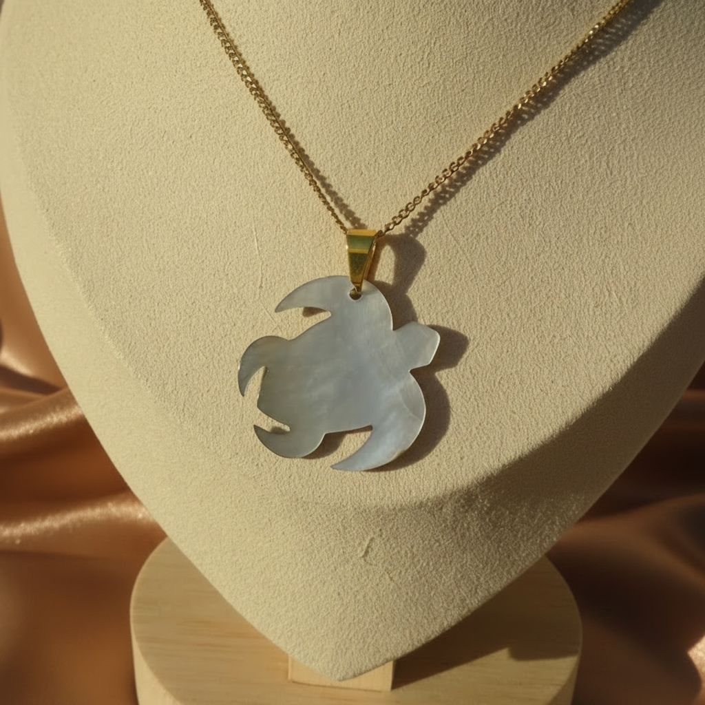 Envers d'un collier en inox 316L doré à chaîne maille gourmette et pendentif tortue des îles en nacre grise.
