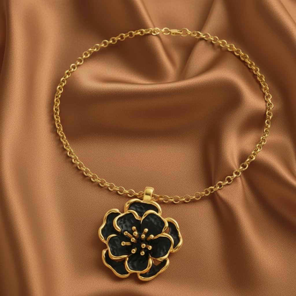 Collier en acier inoxydable doré à chaîne maille rolo orné d'un pendentif grande fleur noire stylisée.