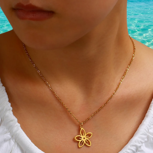 Femme portant un collier doré en acier inoxydable avec pendentif fleur stylisée, bijou bohème
